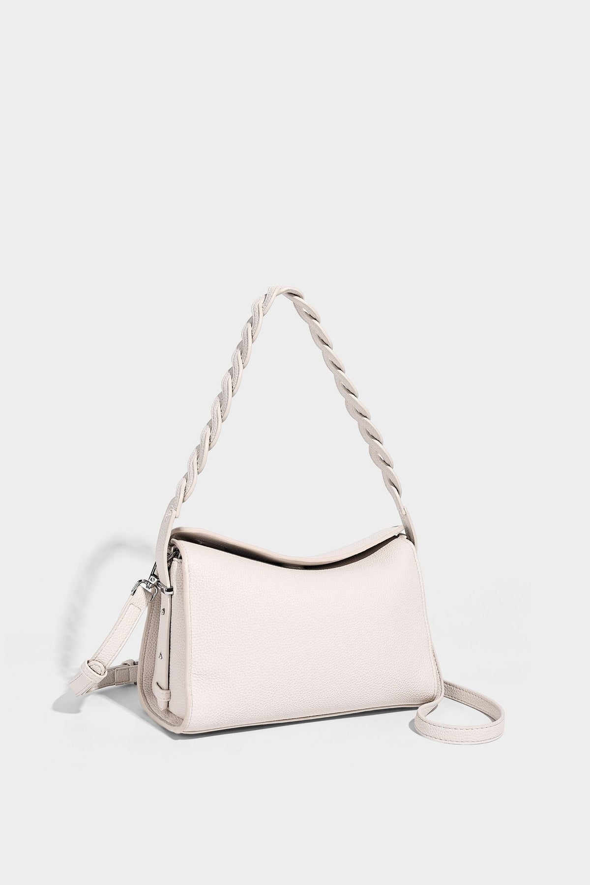 Small structured pebbled-finish shoulder bag with braided top handle, detachable crossbody strap, floral tassel charm, and