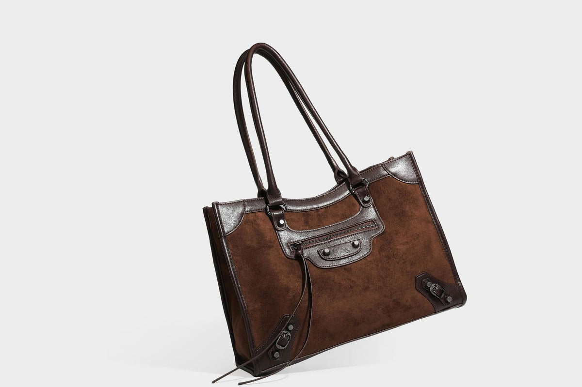 Large structured tote bag with matte suede-like body, smooth leather-look trim, front zip pocket, stud hardware, and