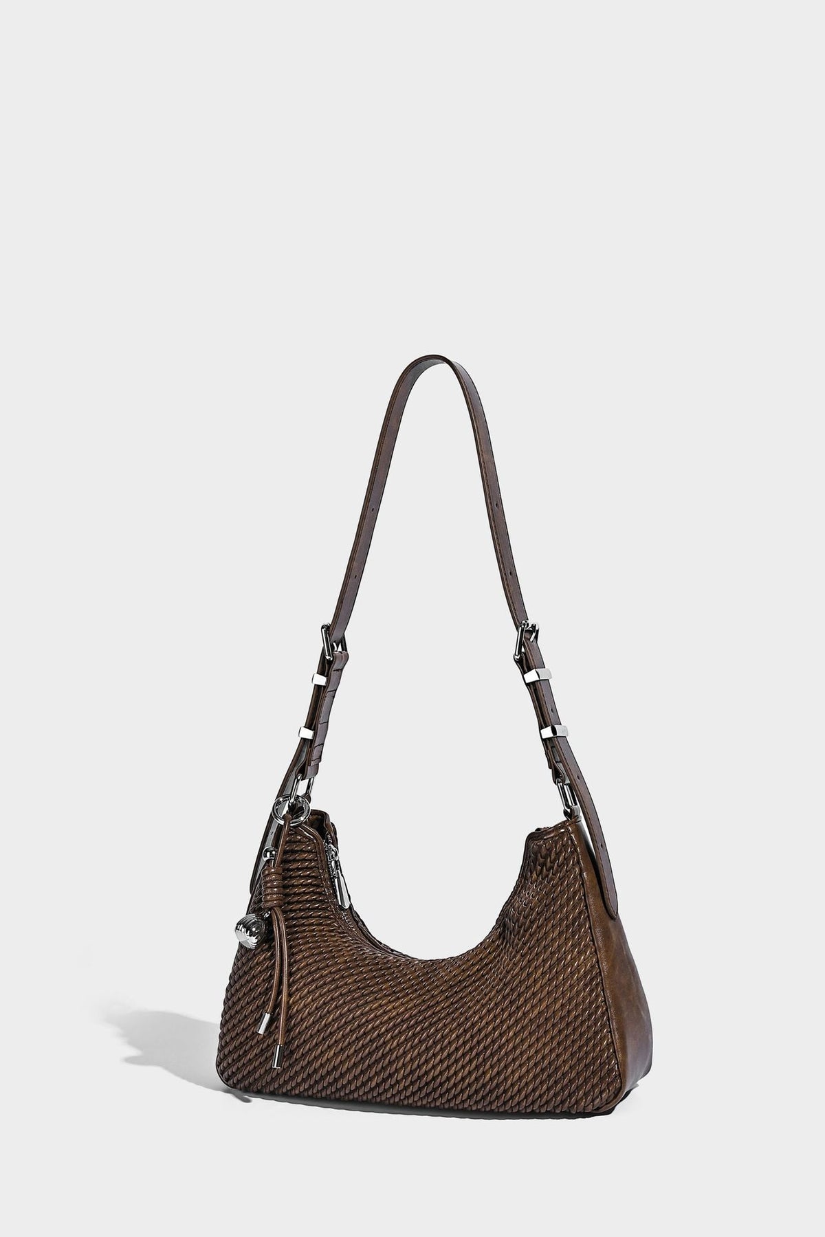 Woven crescent hobo shoulder bag with smooth side panels, zip-top closure, silver-tone charm hardware, and adjustable, detail