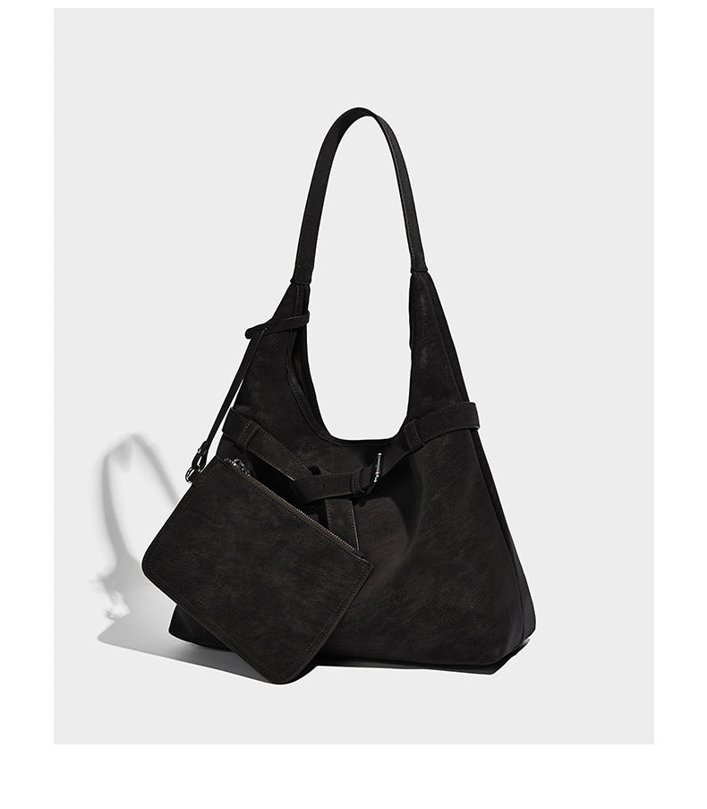 Slouchy oversized shoulder tote bag with matte textured finish, wrap-around buckle strap, and detachable front zip pouch