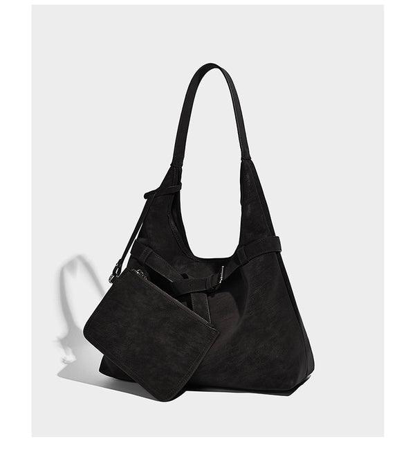 Slouchy oversized shoulder tote bag with matte textured finish, wrap-around buckle strap, and detachable front zip pouch