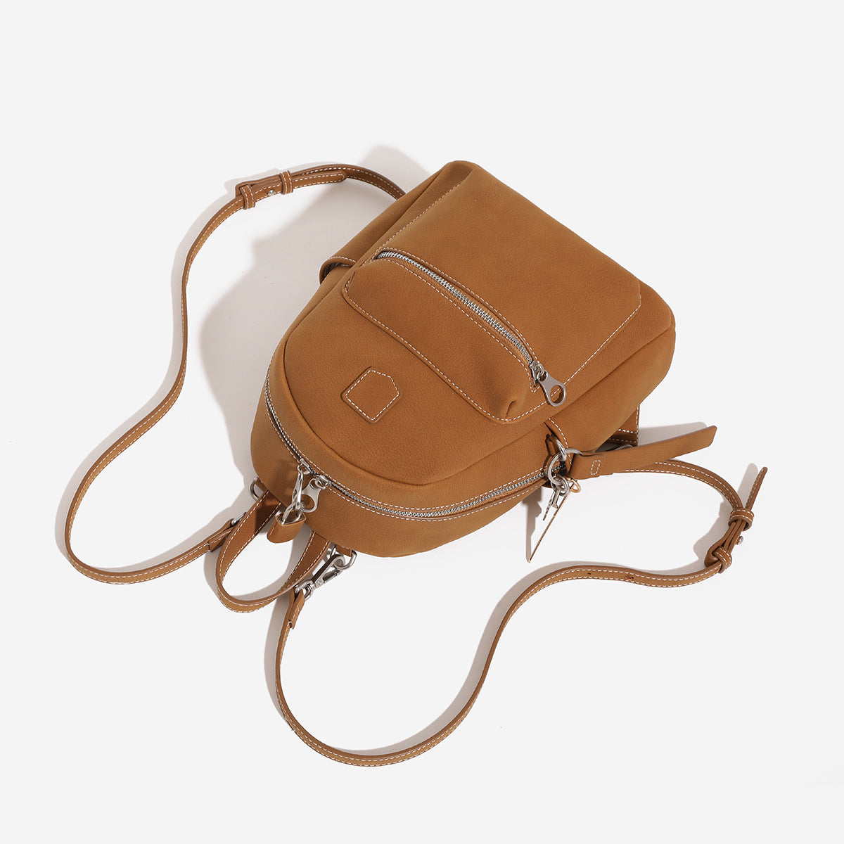 Small rounded mini backpack handbag in pebbled leather-look finish with front zip pocket, silver-tone hardware, and, detail