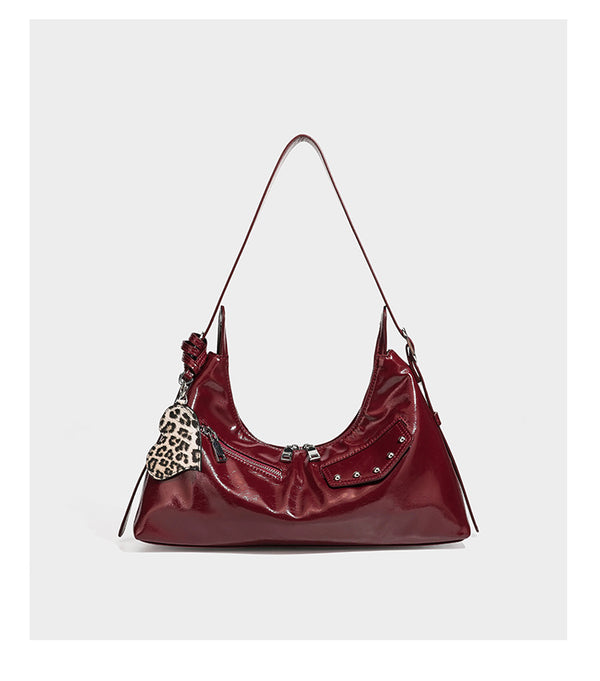 Glossy dark brown hobo shoulder bag with slim strap, front zip pocket, stud detail, and detachable leopard-print heart charm