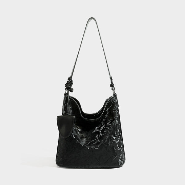 Große Hobo-Schultertasche mit Knitterglanz in tiefem Braun, schmalem verstellbarem Riemen, geknoteten Beschlägen und angesetztem seitlichem Überschlag
