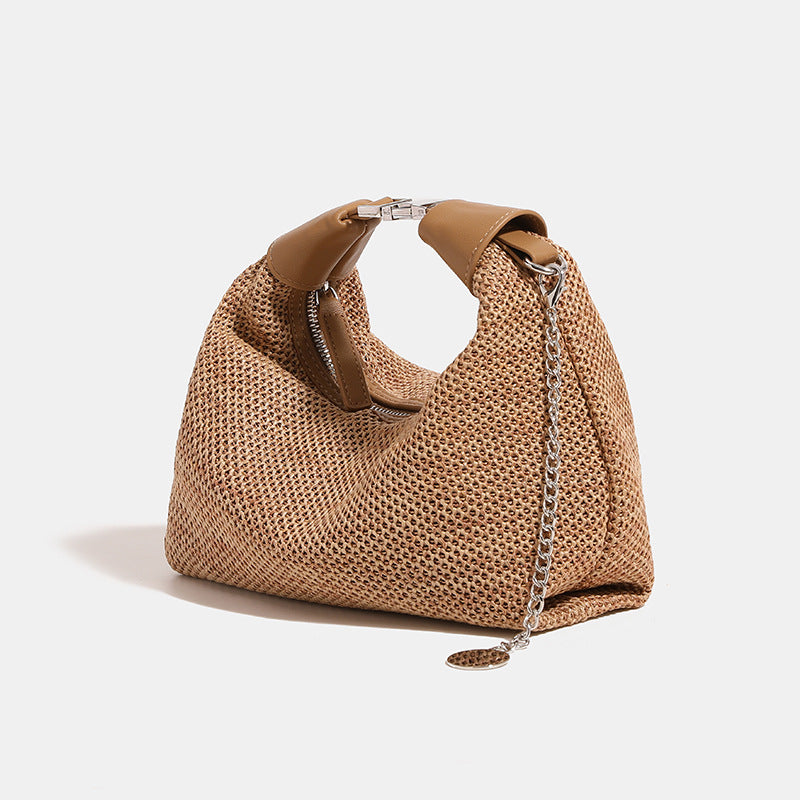 Geflochtene Hobo-Bag aus Stroh mit geknotetem Tragegriff in Lederoptik, silberfarbenen Details und Kettenanhänger in Schwarz und Camel