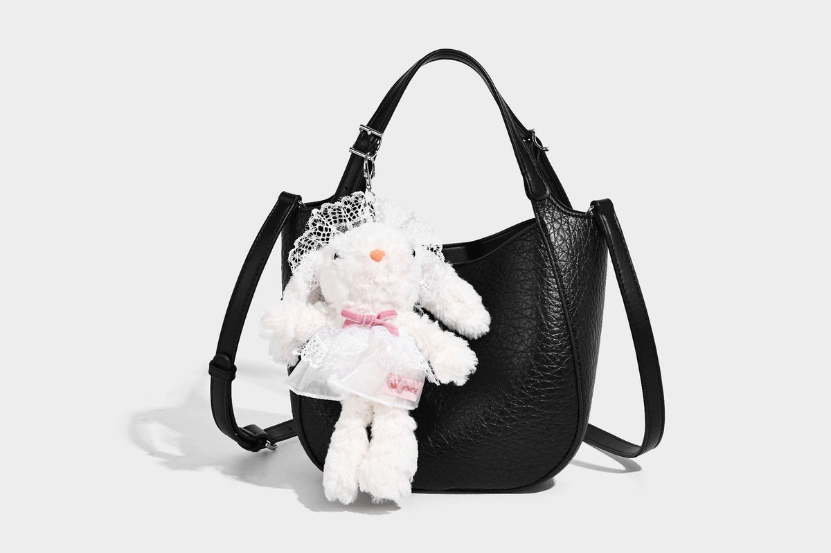 Small pebbled half-moon shoulder bag with dual top handles, detachable crossbody strap, and silver-tone hardware, detail view