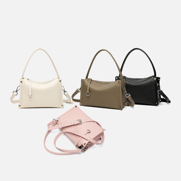 Small structured pebbled-finish convertible bag with silver corner studs, zip top, and detachable shoulder strap, detail view