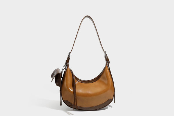Glossy leather-look crescent hobo shoulder bag with dark contrast trim, silver-tone hardware, and attached mini flap pouch
