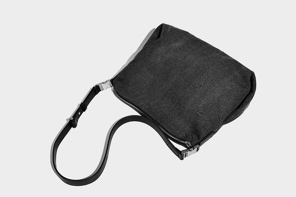 Charcoal denim-textured slouchy hobo bag with zip-top closure, silver-tone hardware, and adjustable leather-look crossbody