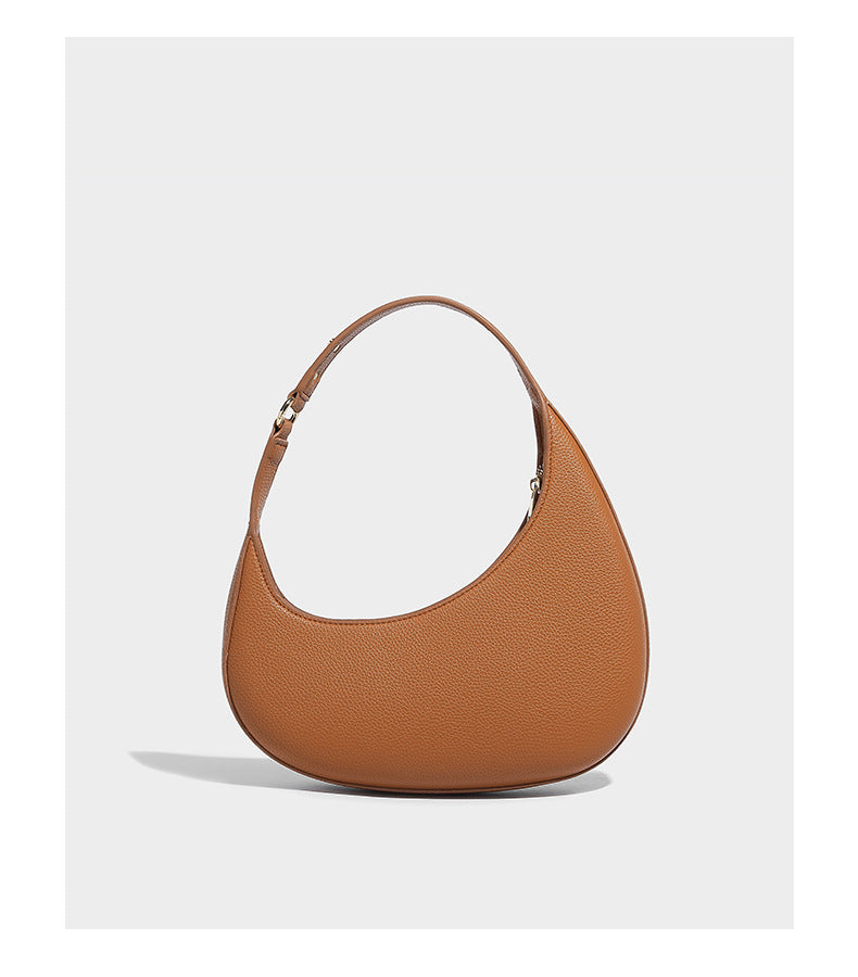 Halbmondförmige Schultertasche mit genarbter Oberfläche, einem einzelnen Schlaufenhenkel und goldfarbenen Reißverschlussdetails, Detailansicht