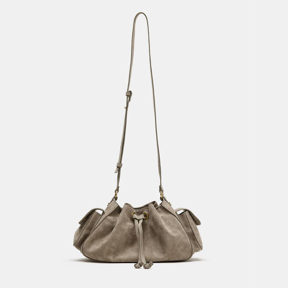 Weiche Beuteltasche in Taupe in Velourslederoptik mit seitlichen Taschen mit Überschlag, Beschlägen in Antikgoldoptik und verstellbarem Crossbody-Riemen