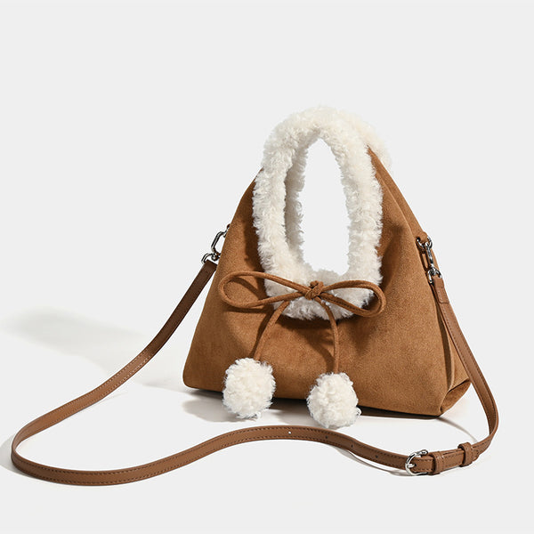 Trapezförmige Tasche aus karamellbraunem Wildlederimitat mit ovalem Henkel aus weißem Kunstfell, Pompon-Kordelverschluss und abnehmbarem Schulterriemen