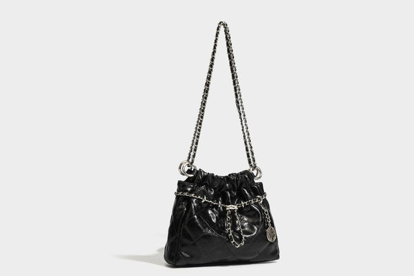 Glossy diamond-quilted drawstring bucket bag with silver chain shoulder strap and medallion charm, detail view 27