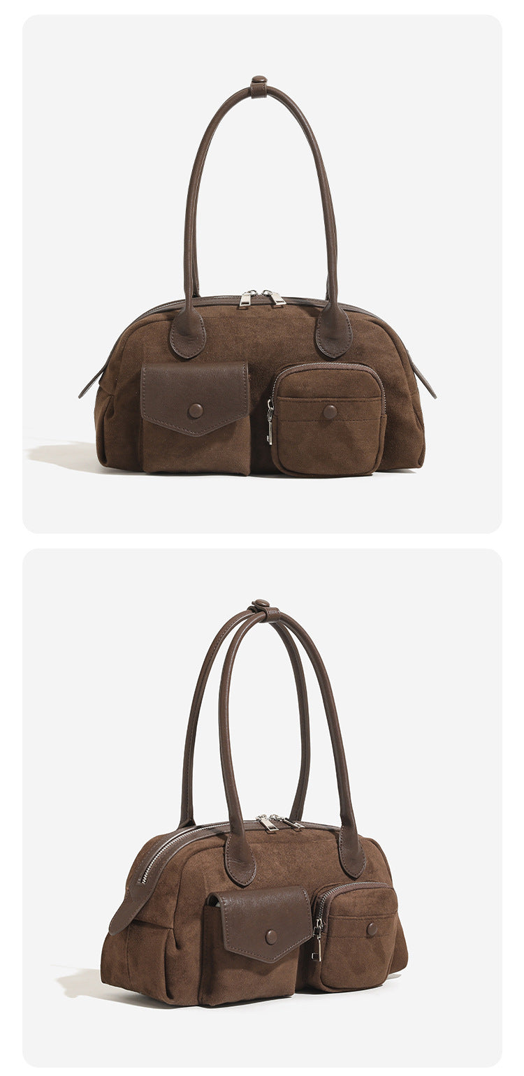 Structured matte leather-look bowling bag with snap-flap and zip front pockets, looped top handles, and antique gold-tone