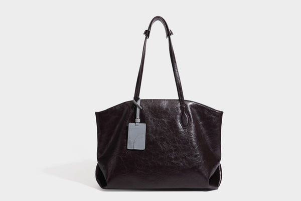 Übergroße, lässig fallende Tote-Bag aus glänzendem, geknittertem Lederimitat in dunklem Burgunderrot mit zwei langen Schulterriemen und kontrastierendem