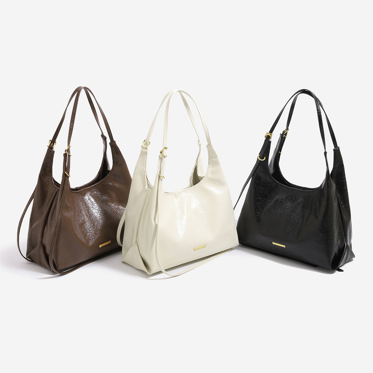 Slouchy hobo shoulder bag in crinkle high-gloss leather-look finish with gold-tone bar hardware and adjustable strap, front