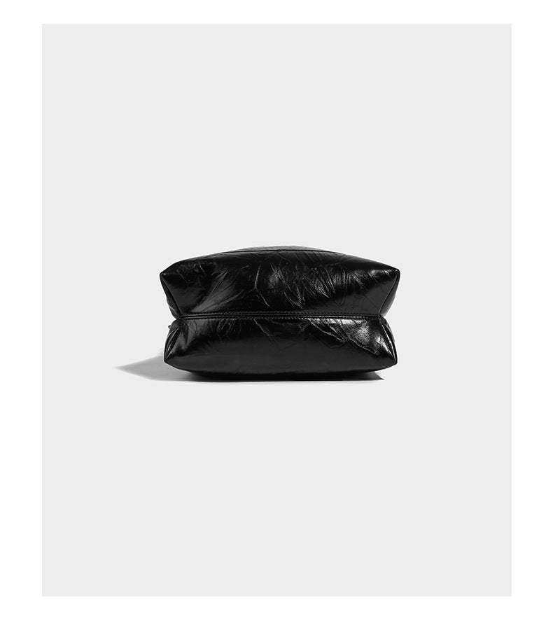 Glossy crinkled ruched drawstring bucket bag with rounded double top handles and detachable chain crossbody strap, detail
