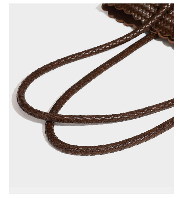 Large open-top woven leather-look tote bag in dark brown with scalloped edge, braided double shoulder straps, and decorative