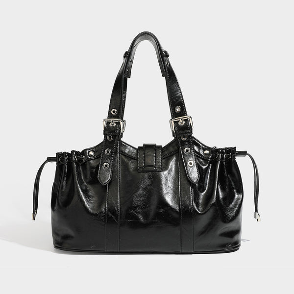 Large black glossy leather-look tote bag with silver buckle straps, eyelet grommet panels, drawstring side gathers, and