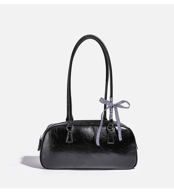 Rounded rectangular shoulder bag with glossy crinkled finish, dual long handles, top zip closure, and gingham ribbon bow