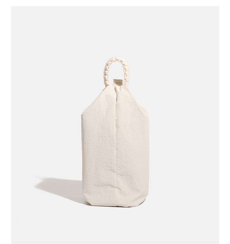 Lässige Crossbody-Tasche aus weichem Stoff mit geflochtenem Tragegriff aus Kordel, diagonalem Reißverschlussfach auf der Vorderseite und silberfarbenen Beschlägen, Detailansicht
