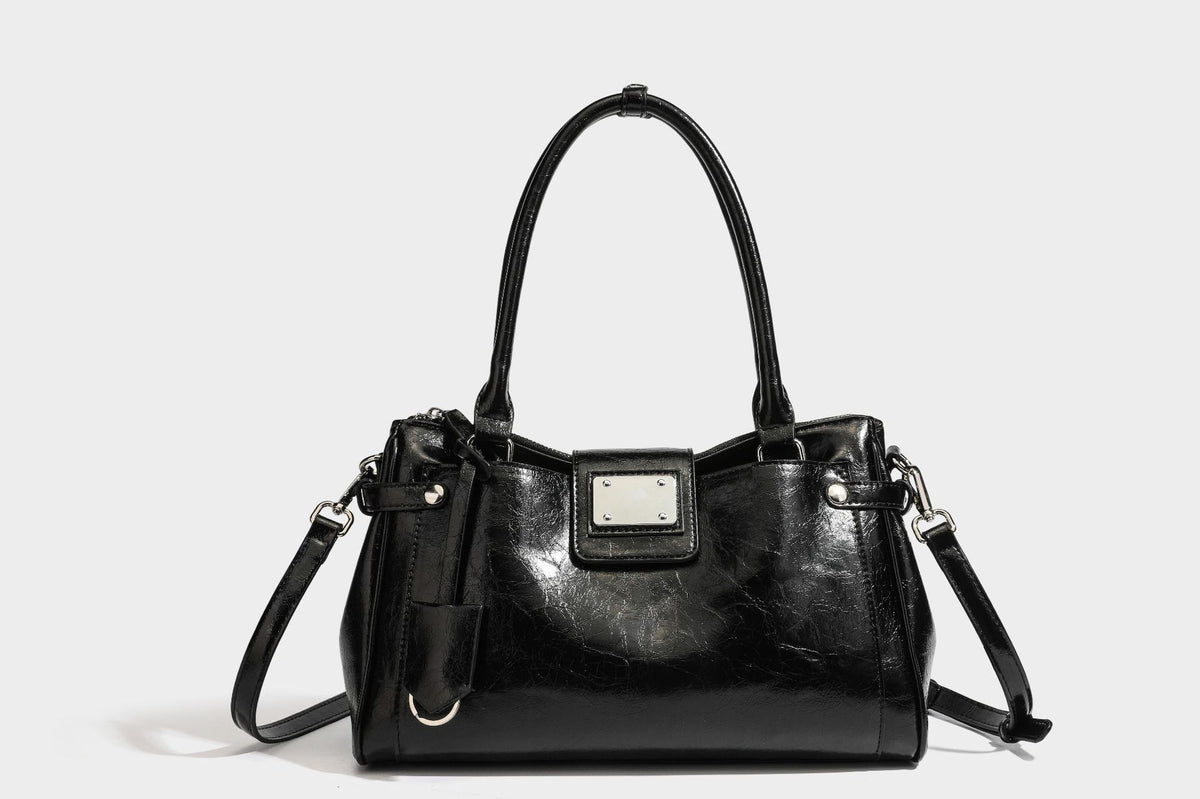 Structured glossy crinkled leather-look satchel with double top handles, front metal-plaque tab, silver-tone hardware, and