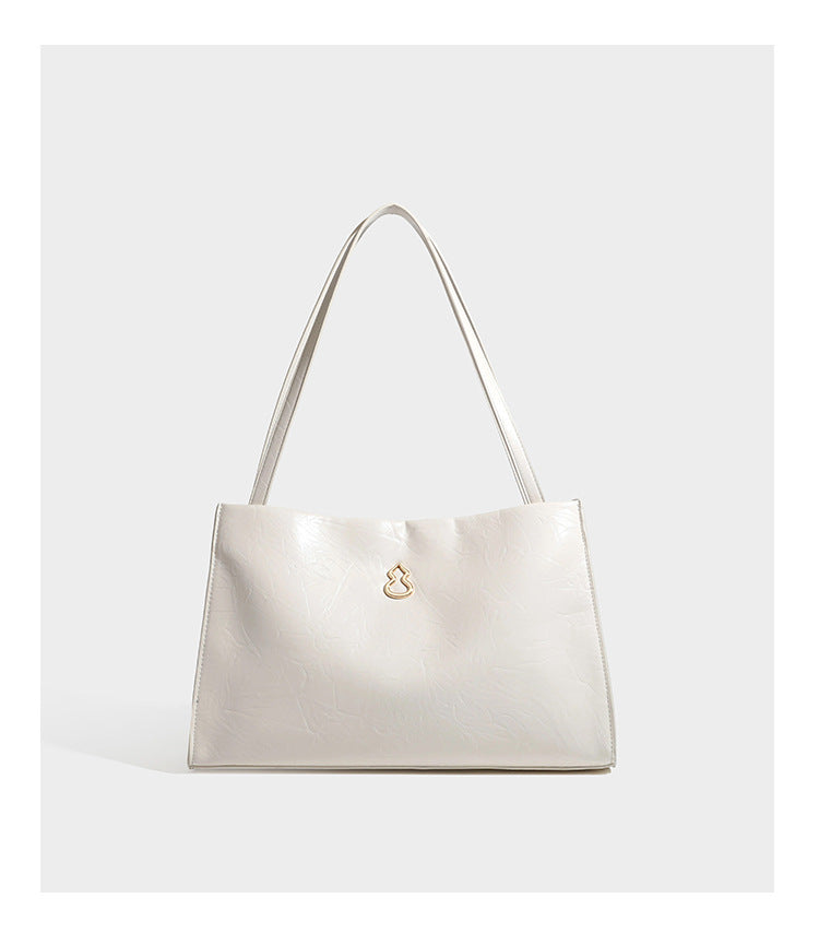 Strukturierte, rechteckige Tote-Schultertasche mit glänzender, geknautschter Lederoptik, langen Doppelriemen und goldfarbenem Emblem