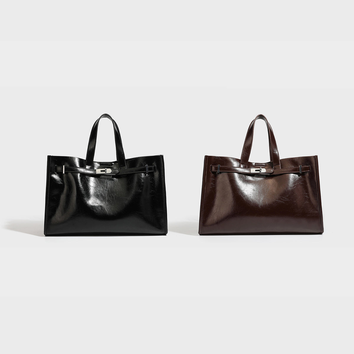 Structured glossy leather-look tote bag with silver turnlock closure, dual top handles, and detachable shoulder strap, detail