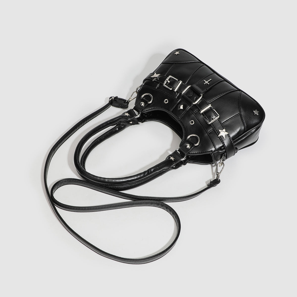 Small structured glossy leather-look crossbody bag with star-stud hardware, buckle strap detail, zip closure, and detachable
