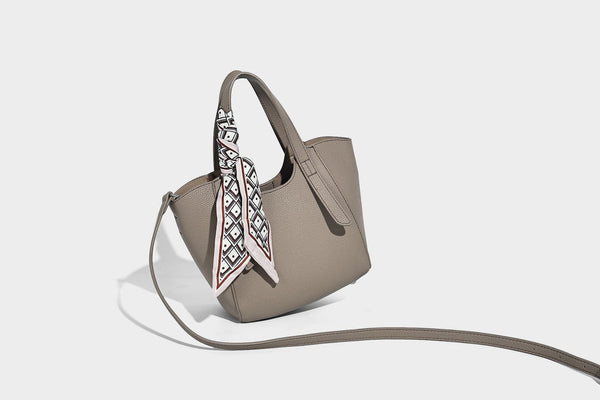 Structured pebbled leather-look tote bag with detachable scarf tie, dual top handles, and adjustable crossbody strap, detail
