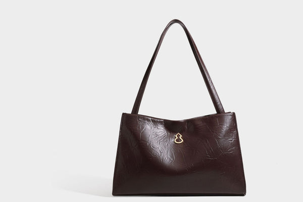 Strukturierte rechteckige Tote-Schultertasche aus glänzender, geknitterter Lederoptik mit langen Doppelträgern und Emblem in Goldoptik