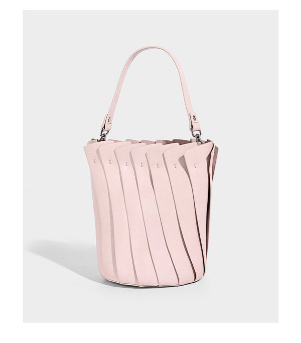 Structured pleated-panel bucket bag with curved top handle and detachable adjustable shoulder strap in smooth matte, detail