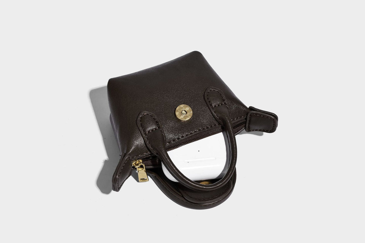 Strukturierte Tote-Bag mit gewebter Oberfläche, befestigtem Mini-Charm-Täschchen, geknoteten Tragegriffen und abnehmbarem Schulterriemen, Detailansicht
