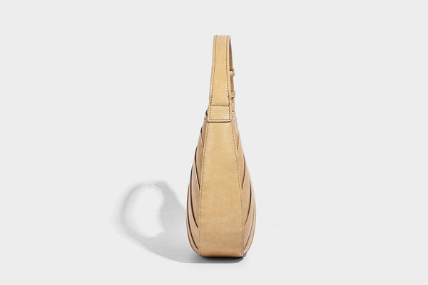 Crescent half-moon shoulder bag with vertical panel seaming, matte-satin leather-look finish, and adjustable gold-tone