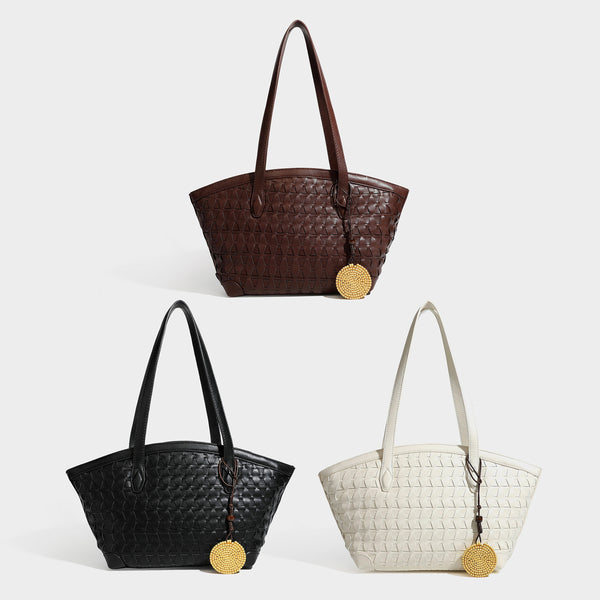Large leather-look tote bag with geometric woven emboss, double shoulder straps, and round woven cord charm in brown, detail