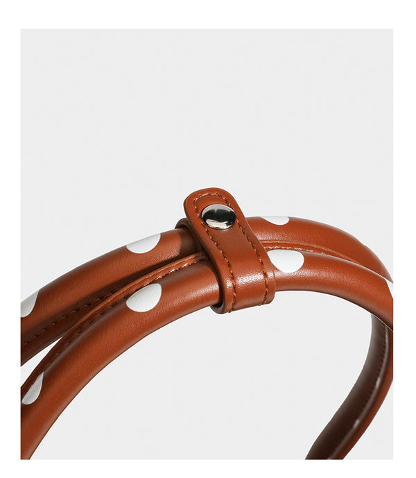 Strukturierte Baguette-Tasche mit Polka-Dot-Muster, glänzender Lederoptik, zwei Tragegriffen, silberfarbener Drehverschlussklappe und
