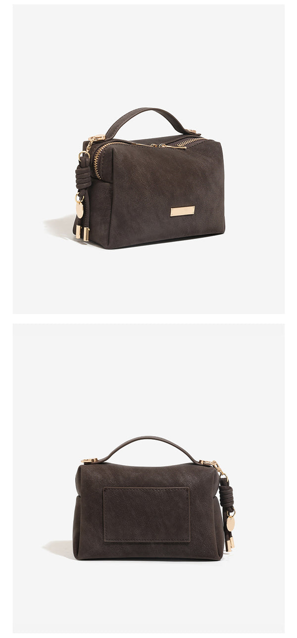 Mini-Crossbody-Tasche mit kastiger Form und Tragegriff, matter strukturierter Oberfläche in Lederoptik, Reißverschluss-Hardware in Goldoptik und seitlichem Quastendetail