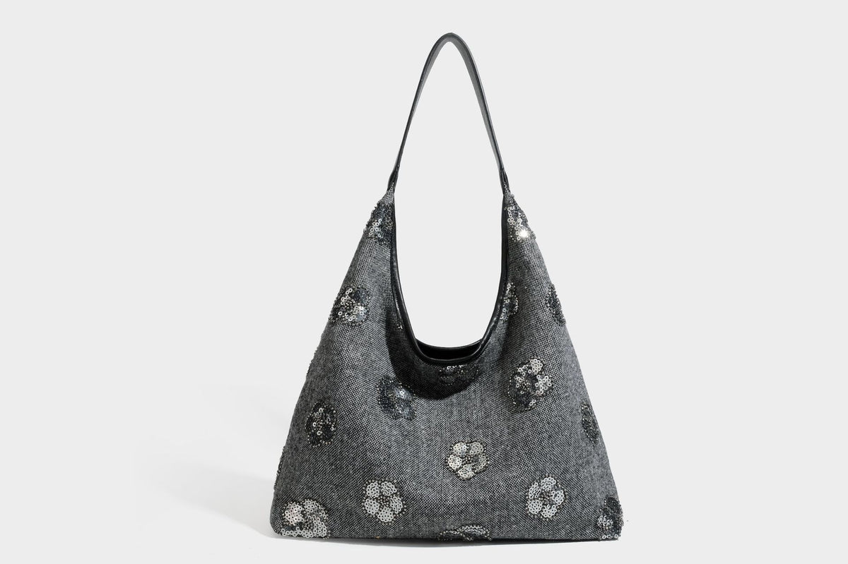 Lässig fallende, trapezförmige Schulter-Tote in Anthrazitgrau mit floralen Paillettenmotiven in Silber, Riemen in Lederoptik und herabhängendem Perlenbesatz