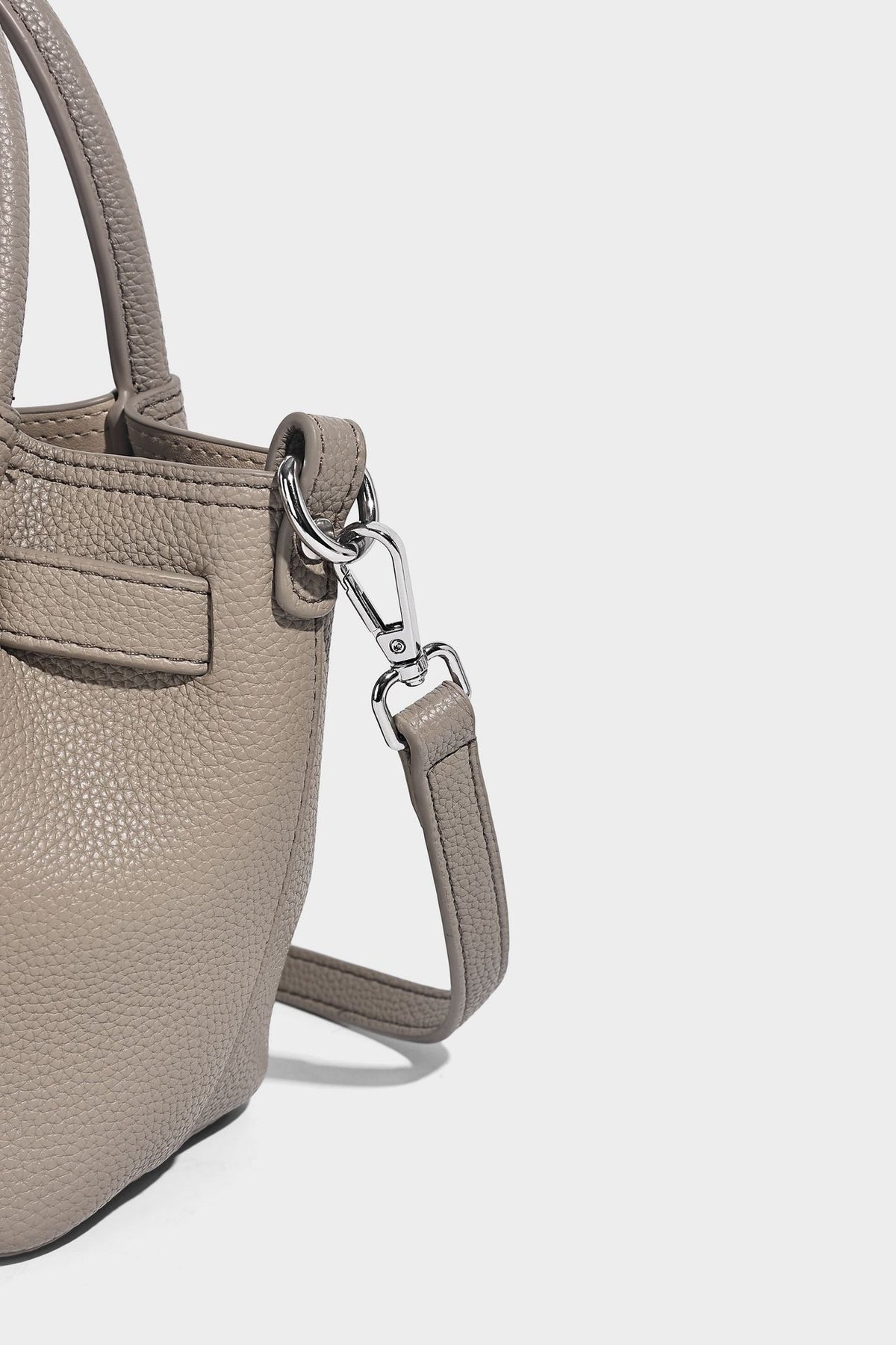 Kleine strukturierte Henkeltasche aus genarbtem Material in Taupe mit zwei Henkeln, bedrucktem Schalband, vorderem Drehverschluss und, Detail