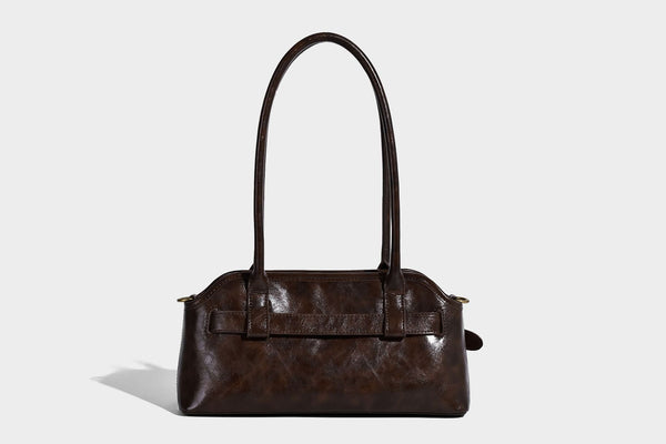 Strukturierte dunkelbraune Henkeltasche mit Öl-Wachs-Finish, vorderer Gürtelschnalle, goldfarbenen Beschlägen und zwei Tragegriffen, Detailansicht