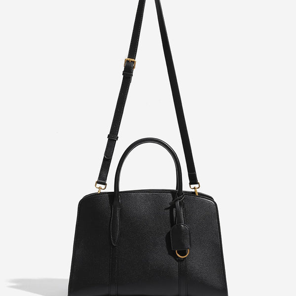 Structured trapezoid Boston satchel bag with dual top handles, gold-tone lock charm, and top zip closure, detail view 2