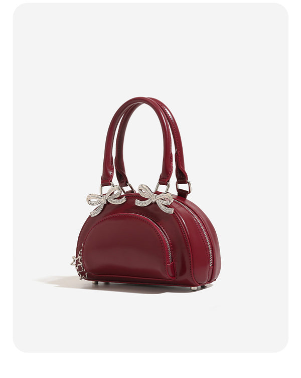Structured half-moon mini handbag with silver-tone crystal bow hardware and star charm chain, detail view 8
