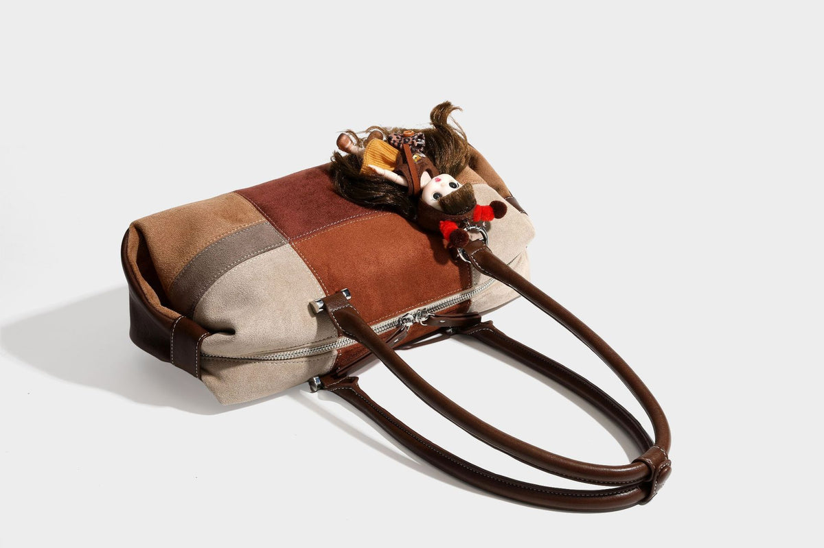 Patchwork suede-look barrel shoulder bag in brown, rust, tan, beige, and gray panels with double leather-look straps and