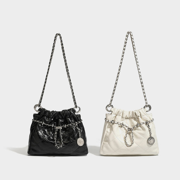 Glossy diamond-quilted drawstring bucket bag with silver chain shoulder strap and medallion charm, detail view 2