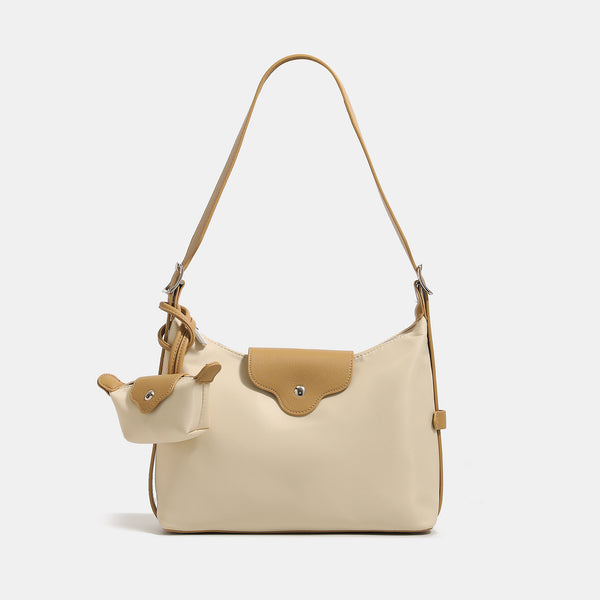 Slouchy hobo shoulder bag in smooth fabric with leather-look tan trim, zip-top closure, adjustable strap, and detachable
