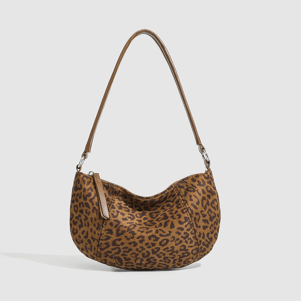Brown and tan leopard print crescent hobo shoulder bag with zip top closure, front zip pocket, and adjustable silver-tone