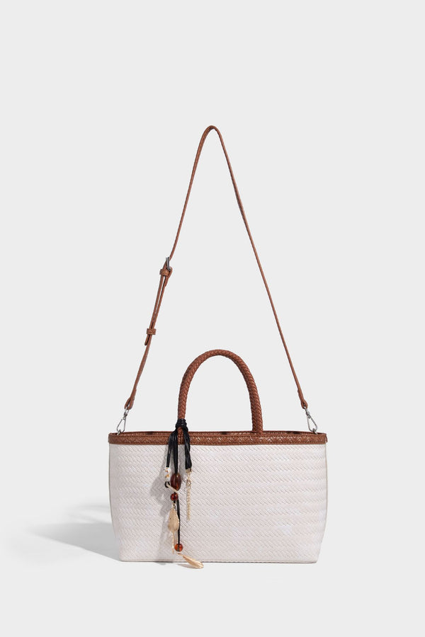 Structured woven-texture tote bag with brown braided top handles, decorative tassel charm, and detachable shoulder strap