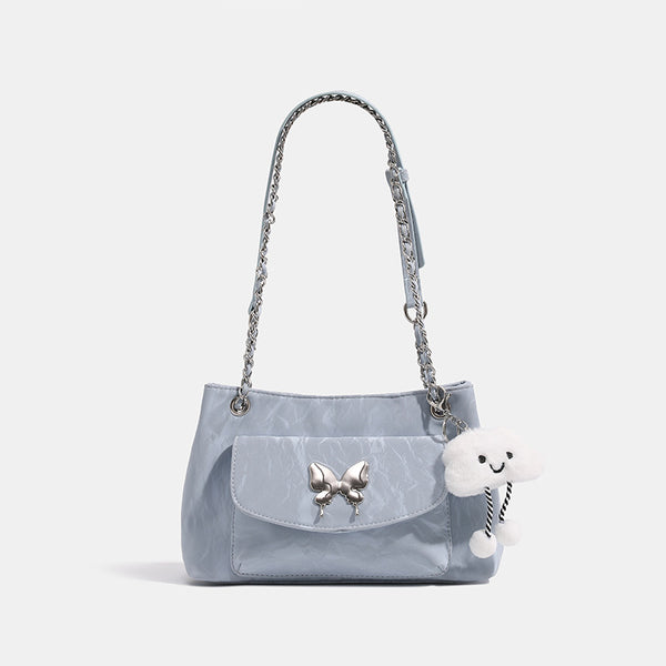 Soft rectangular glossy leather-look shoulder bag with silver chain strap, butterfly ornament on front flap pocket, and