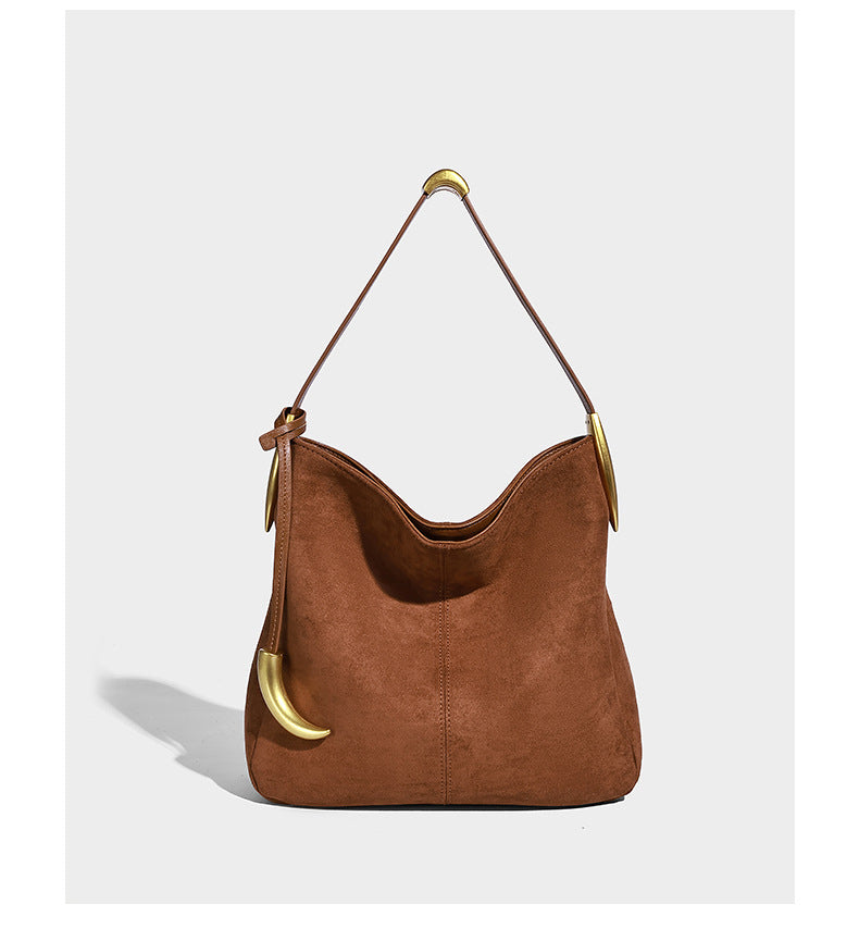 Beige-braune Hobo-Schultertasche mit lässiger Silhouette, matter Veloursleder-Optik, goldfarbenen halbmondförmigen Beschlägen und schmalem Schulterriemen, Detailaufnahme