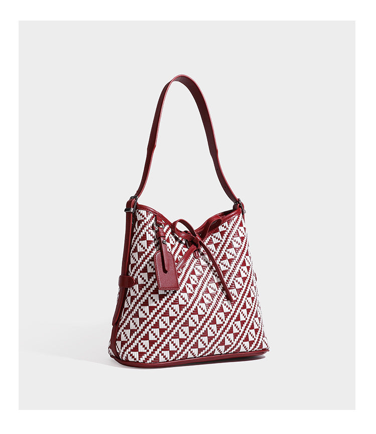 Woven geometric bucket shoulder bag in white and dark brown two-tone pattern with leather-look trim and drawstring top